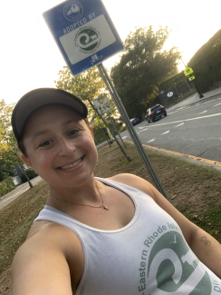 Person standing next to adopt a spot sign